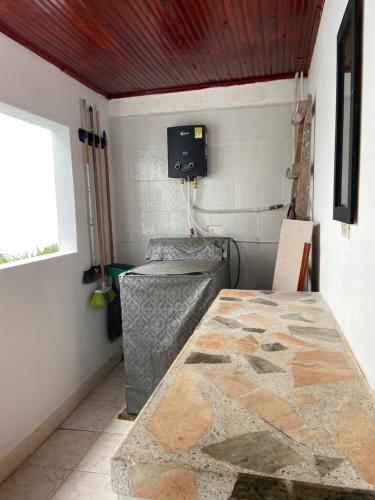 a room with a table and a couch and a window at Hostal Amelia Filandia in Filandia