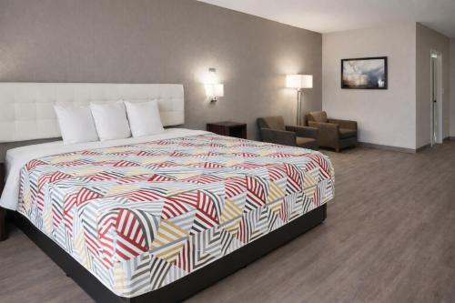 a hotel room with a bed and a chair at Motel 6 Lake City, FL – Medical Center in Lake City