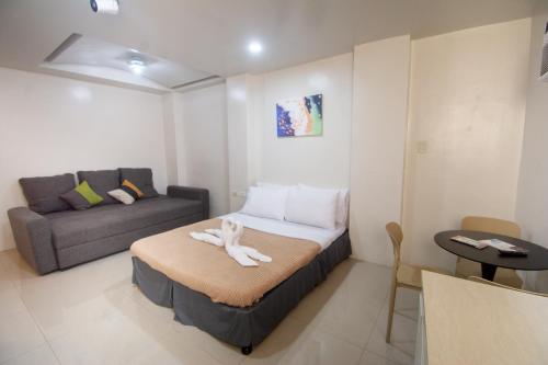 a small room with a bed and a couch at ILA Apartelle Boracay in Boracay