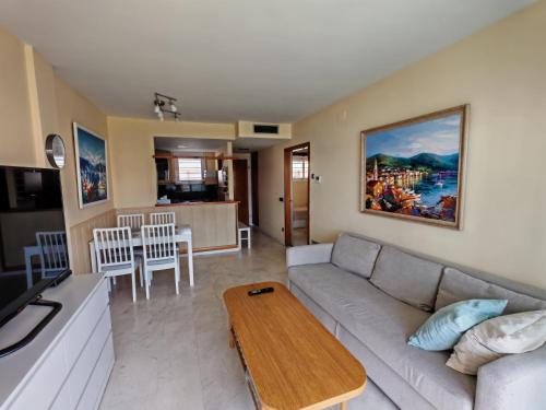 a living room with a couch and a table at Seafront apartment S'Abanell Central Park with pool in Blanes