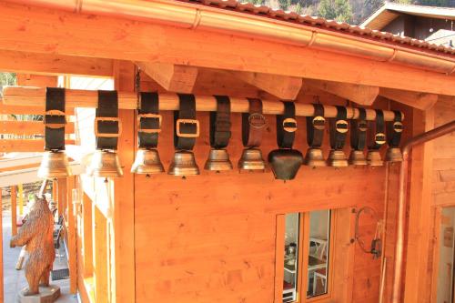 a bunch of bells hanging on the side of a building at Chalet-Gafri - BnB - Frühstückspension und Gastfreundschaft in Wilderswil