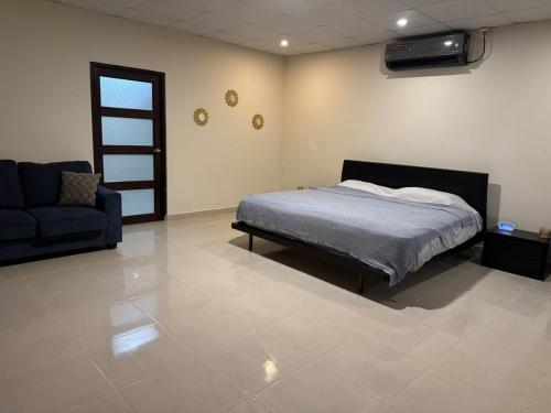 a bedroom with a bed and a couch at Fourth Studio and Festivities in Guararé