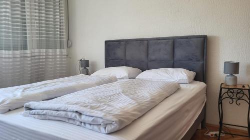 a bedroom with two beds with white blankets and pillows at Apartman Andjela in Tivat