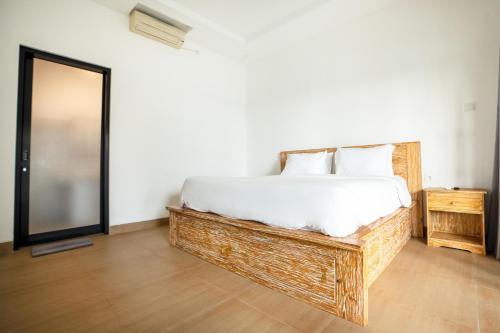a bedroom with a large bed and a mirror at 2BR Rice Field View Private Villa in Cemagi in Canggu