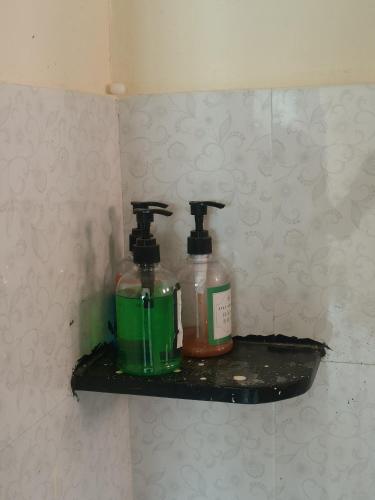 two bottles sitting on a shelf in a bathroom at 2 BHK All AC Rooms Solapur Home Stay By Stay Nestura in Solapur