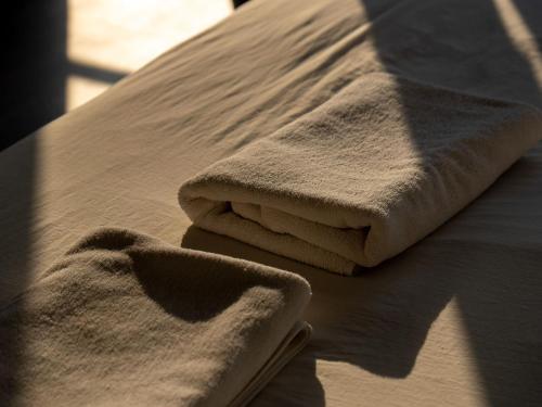 a pile of towels sitting on top of a bed at Riverside Houayxay Hotel in Ban Houayxay
