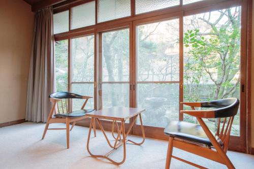 two chairs and a table in front of a window at Bansuirou Fukuzumi in Hakone