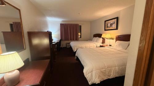 a hotel room with two beds and a mirror at clarion hometown inn in Clarion