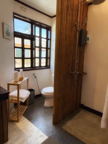 a bathroom with a toilet and a wooden door at Marina 4Rooms in San Vicente