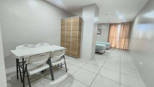 a white room with a table and chairs in it at LTG Grand Hotel Cebu in Cebu City