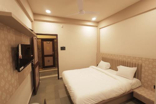 a small bedroom with a bed and a television at Hotel Best Inn in Valsād