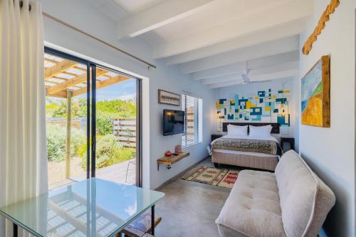 a bedroom with a bed and a glass table at The Warren @White.Rabbit.House in Plettenberg Bay