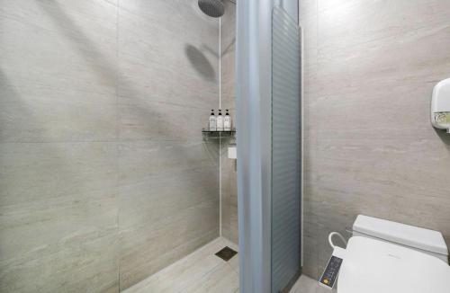a bathroom with a shower with a white toilet at Daejeon Yuseong MAC Hotel in Yusŏng