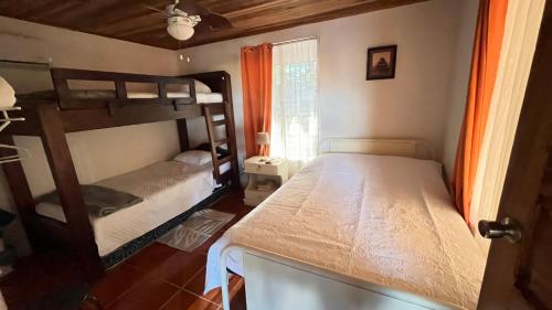 two bunk beds in a room with a window at Casa Pochote, Cobano in Cóbano