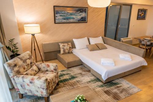 a living room with a bed and a couch and a chair at Capitоl Suites & Apartments in Skopje