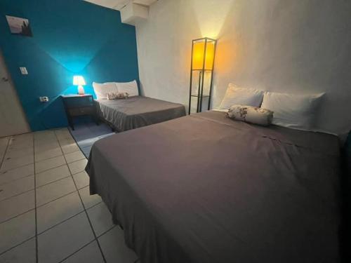 a hotel room with two beds and a table with a lamp at casa de elena in Santa Ana