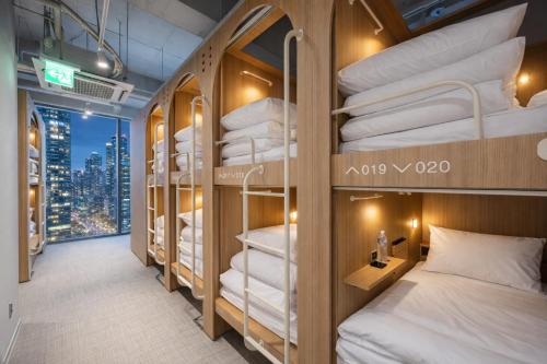 a room with bunk beds with a view of the city at Haeundae Marine Capsule Hotel&Spa in Busan