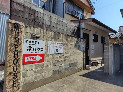 a building with signs on the side of it at 町中ステイ 宗ハウス in Nachikatsuura