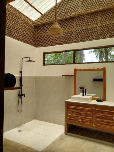 a bathroom with a sink and a mirror at LalaMafia Bungalow in Utende