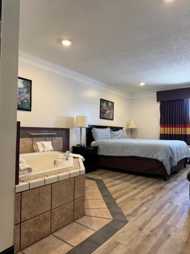 a bedroom with a bed and a bath tub at Home Suites in Thief River Falls