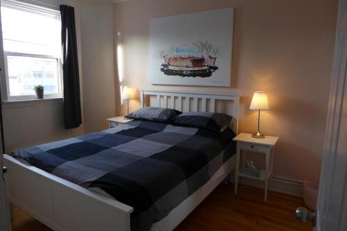 a bedroom with a bed with a blue and black blanket at Downtown Apt #6 Amazing View - 23 Queen's Rd in St. John's