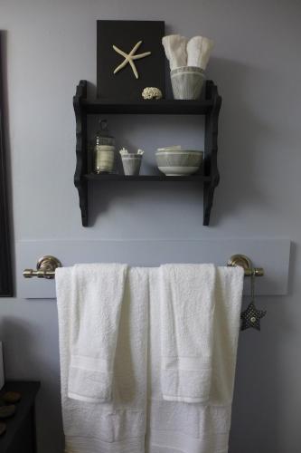 a bathroom with white towels hanging on a shelf at Downtown Apt #6 Amazing View - 23 Queen's Rd in St. John's