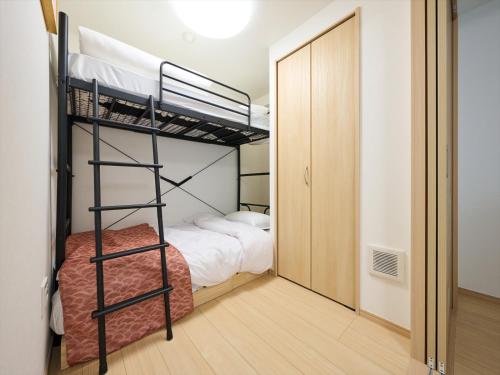 a bedroom with two bunk beds and a closet at K-Stay TOKYO HANEDA in Tokyo