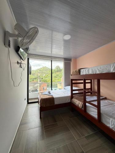 ein Schlafzimmer mit zwei Etagenbetten und einem Fenster in der Unterkunft Hotel Lancan - Pauna, Boyacá in Pauna