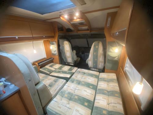 an inside view of an rv with a bed and chairs at Autocaravana Dethleffs Globetrotter in Viana do Castelo