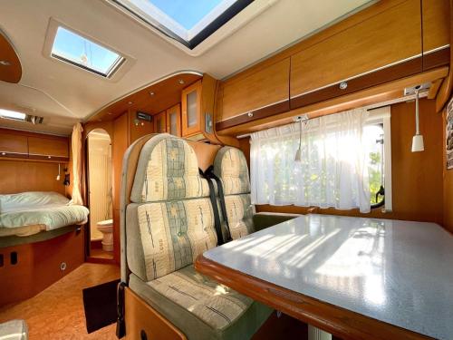 a train room with a table and a bed at Autocaravana Dethleffs Globetrotter in Viana do Castelo