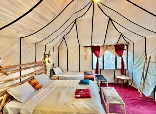 a bedroom with two beds in a tent at Best Classic Sahara Experiences in Merzouga