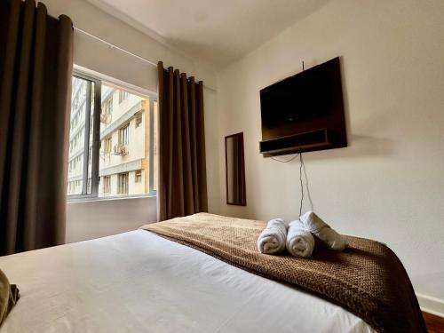 a bedroom with a bed with towels on it at Apartamento Premium Liberdade in São Paulo