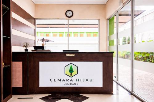 a reception desk in a building with a clock on the wall at RedDoorz Plus near The Great Asia Africa Lembang in Bandung