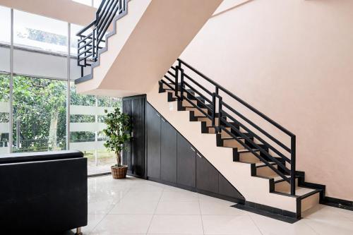 a staircase in a house with black railings at RedDoorz Plus near The Great Asia Africa Lembang in Bandung