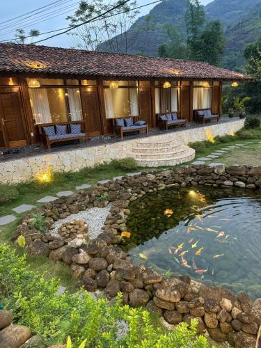 a koi pond in front of a building at Cheers Ecolodge Du Già in Làng Cac