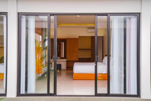 a room with sliding glass doors leading to a bedroom at Pondok Uma Jero in Tanah Lot