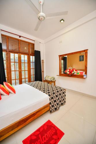 a bedroom with a large bed and a mirror at Summerland Residence in Udawalawe