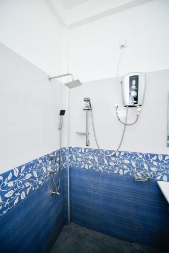 a bathroom with a shower with blue tiles at Summerland Residence in Udawalawe