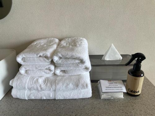 a pile of towels on a counter next to a bottle of soap at Cabinet 캐비넷 양양 in Yangyang