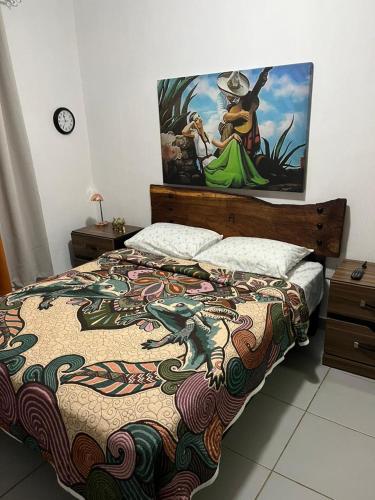a bedroom with a bed with a painting on the wall at Hospedaje Samao in Santa María del Oro