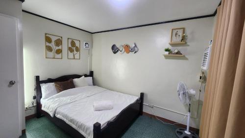 a bedroom with a bed and a fan at Raed Homestay by ASH in Biñan