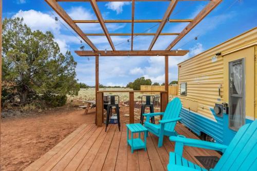 a deck with blue chairs on a house at Grand Canyon Stargazing Camper in Williams