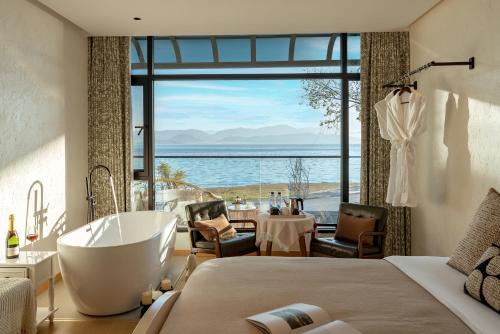 a bedroom with a tub and a view of the ocean at Blue Sea Hotel in Dali