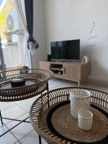 a living room with two tables and a tv at Ti Coin Soleil in Saint-Paul