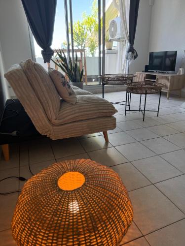 a living room with a couch and a table at Ti Coin Soleil in Saint-Paul