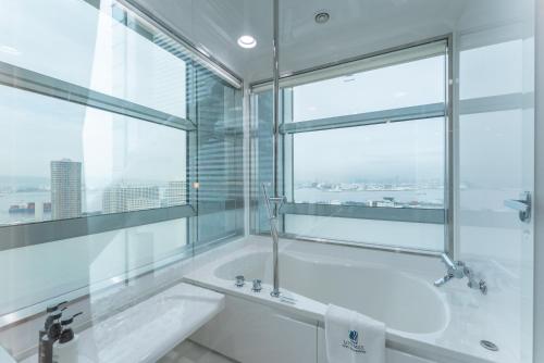 a bathroom with a tub and a large window at LiVEMAX Sakishima Cosmo Tower Hotel in Osaka