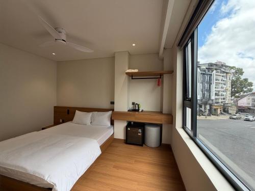 a small bedroom with a bed and a window at Toàn Thịnh Hotel in Da Lat