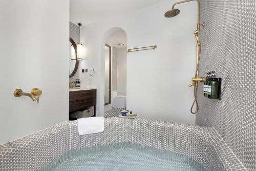 a bathroom with a tub with a sink and a shower at Paul Chabot Hotel in Hai Phong