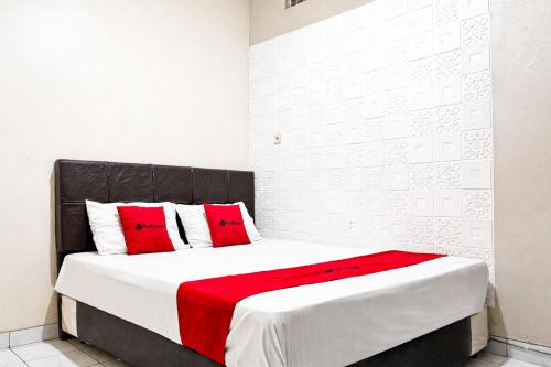 a bedroom with a large bed with red pillows at RedDoorz Syariah at Cimahi in Cimindi