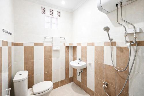 a bathroom with a shower and a toilet and a sink at RedDoorz Syariah at Cimahi in Cimindi